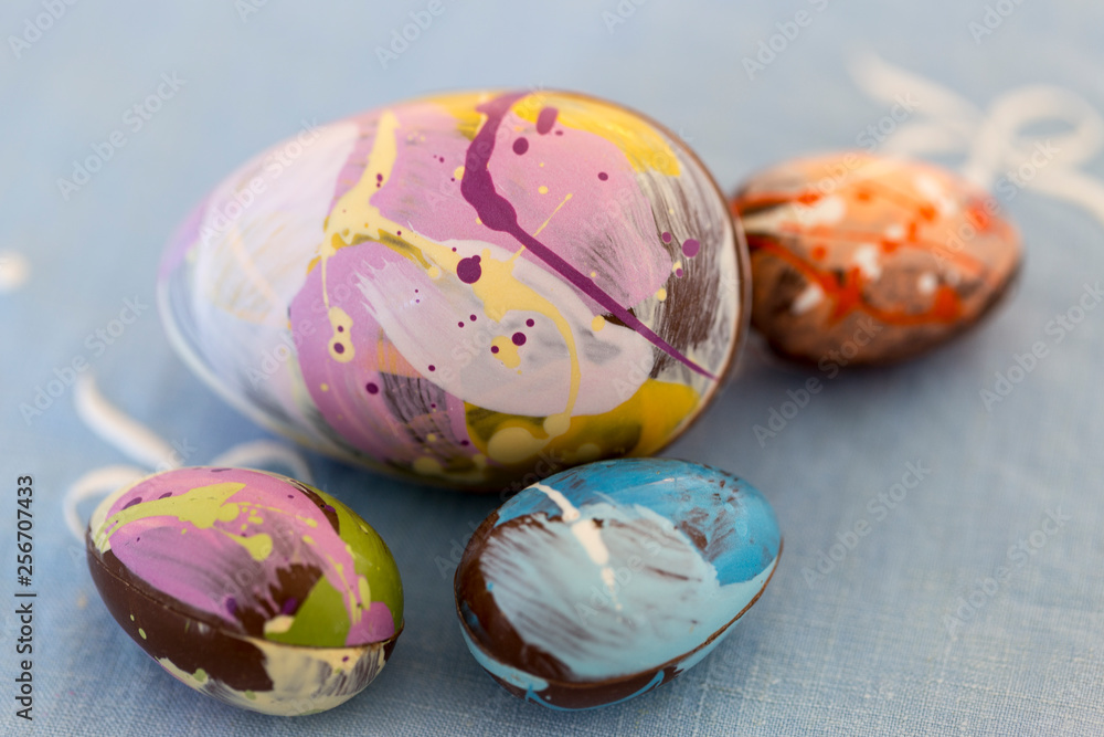 Closeup of colorful homemade painted Easter eggs against pretty vintage pale blue tablecloth