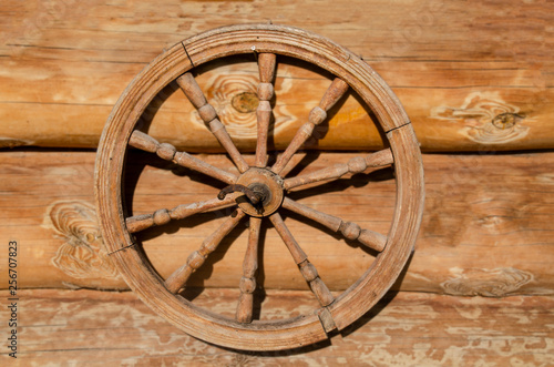 Old wooden wheel from the cart. Wooden background. © t.karnash