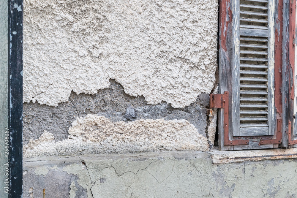 Naklejka premium Eine beschädigte Hausmauer und abgeplatzter Außenputz mit einem großen Loch, Deutschland