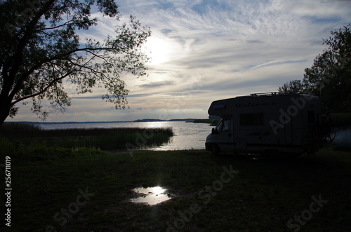 kamper nad jeziorem o zachodzie słońca