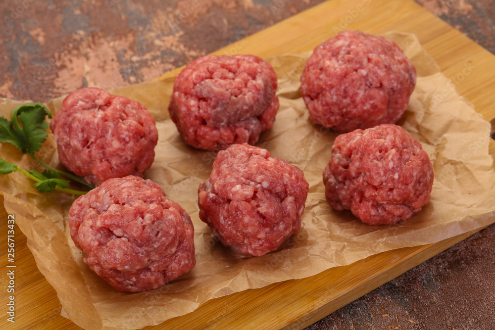 Raw meatball over wooden background Raw meatball over wooden background