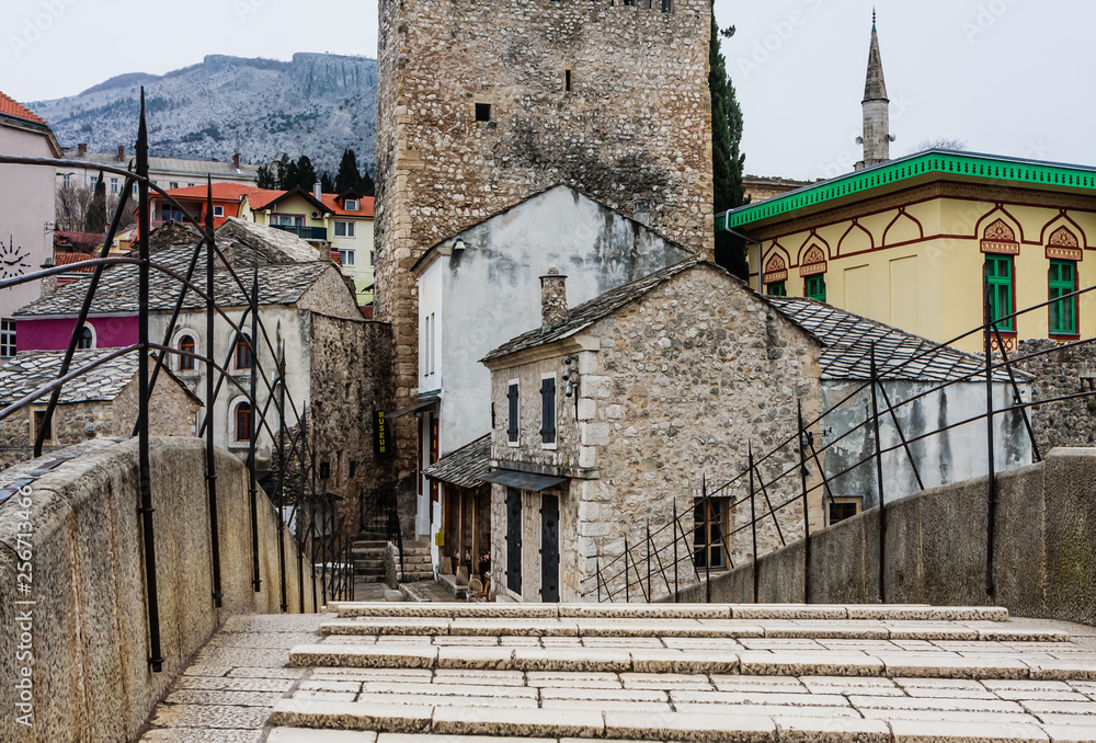 View of the historic Old Bridge in Mostar, Bosnia and Herzegovina with a church tower in the background