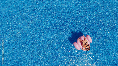 Top view of twobeautiful girls swim in the pool for flamingos