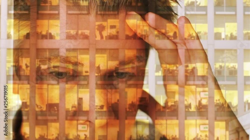 Reflection of a caucasian businessman looking out of a window with an office behind themes of working late office overworked