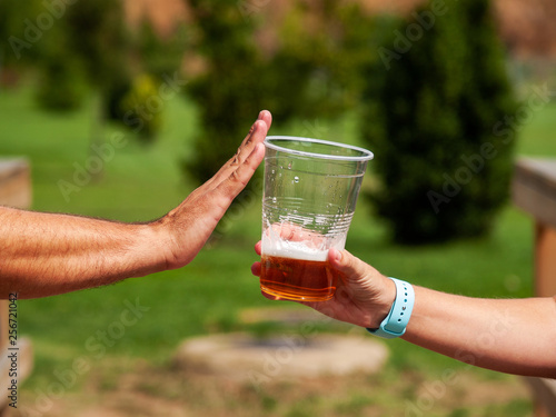 Stop alcohol concept. A man making a stop gesture to a glass of beer