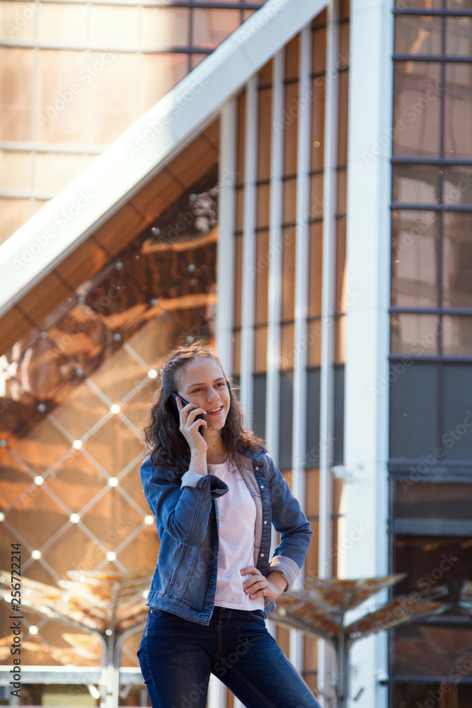 Fototapeta premium teen girl having a mobile phone talk in a large metropolis