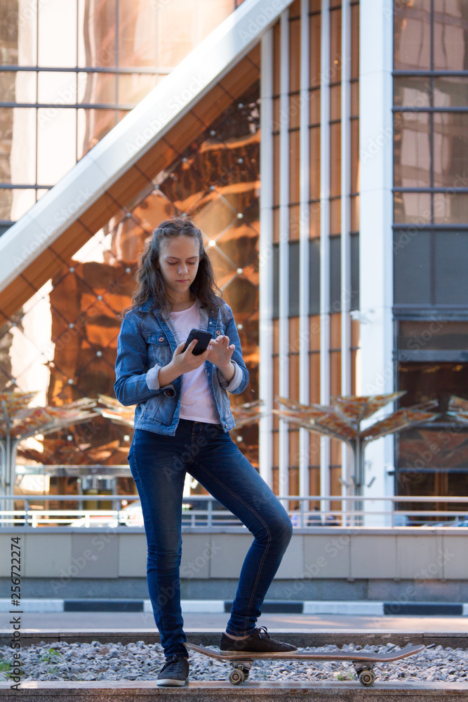Fototapeta premium teen girl look at a smartphone in a large metropolis
