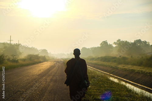 Buddhist monk walking on rural road
