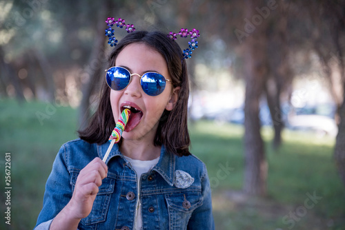 pretty girl poses eating a candy