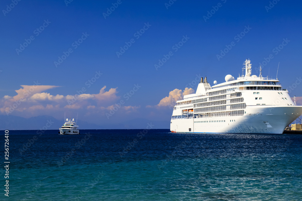 Seascape.  A large white cruise ship stands in the tourist sea  port at sunset, Rhodes, Greece. Travel, recreation and vacation.  Liner on the ocean