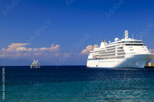 Seascape. A large white cruise ship stands in the tourist sea port at sunset, Rhodes, Greece. Travel, recreation and vacation. Liner on the ocean