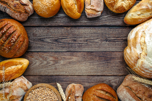 Assortment of baked bread on wooden table background,top view
