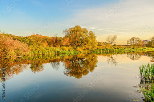 Colorful autumn landscape with blue river and yellow trees