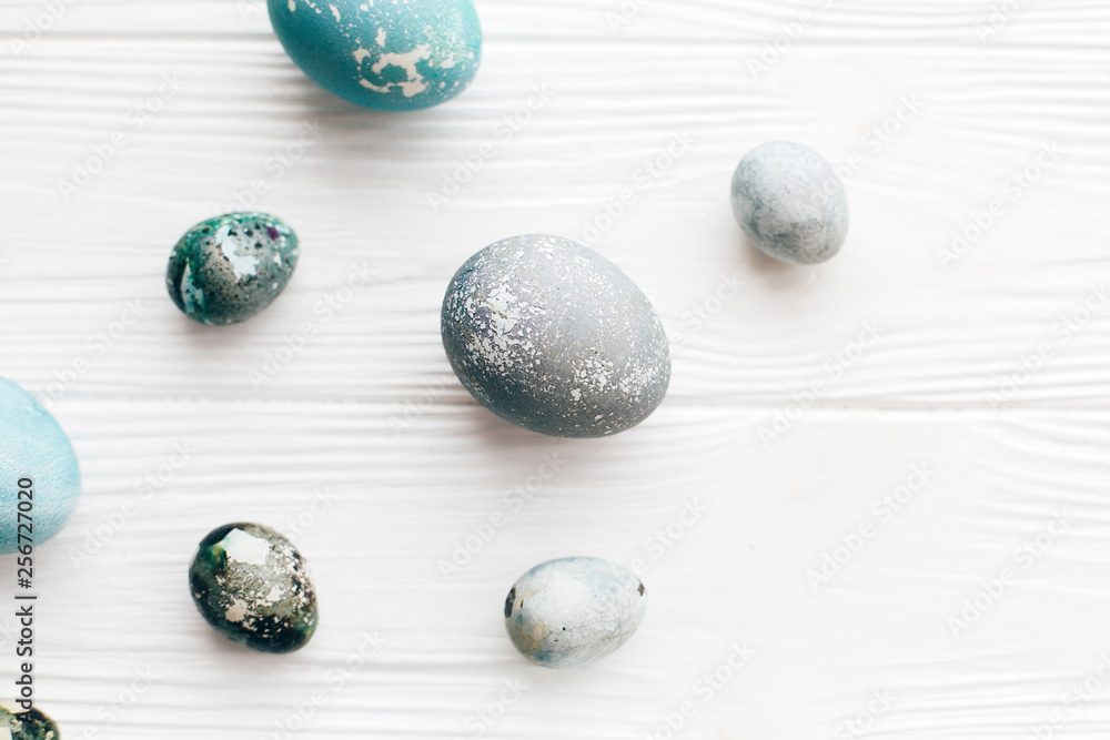 Stylish Easter eggs flat lay on white wooden background with space for text. Modern easter eggs painted with natural dye in blue marble. Happy Easter concept, greeting card mockup Stylish Easter eggs flat lay on white wooden background with space for text. Modern easter eggs painted with natural dye in blue marble. Happy Easter concept, greeting card mockup