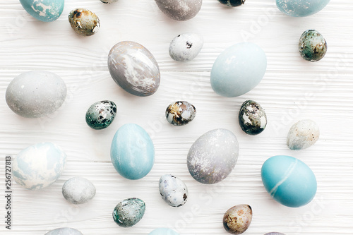 Happy Easter, greeting card image. Stylish Easter eggs flat lay on white wooden background. Modern easter eggs painted with natural dye in blue and grey marble.