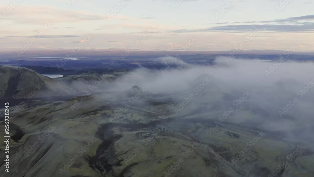 Aerial drone shot of clouds rolling over mountains of Landmannalaugar at dawn, Highlands of Iceland Aerial drone shot of clouds rolling over mountains of Landmannalaugar at dawn, Highlands of Iceland