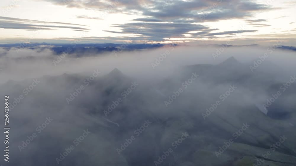 Aerial drone shot of clouds rolling over mountains of Landmannalaugar at dawn, Highlands of Iceland Aerial drone shot of clouds rolling over mountains of Landmannalaugar at dawn, Highlands of Iceland