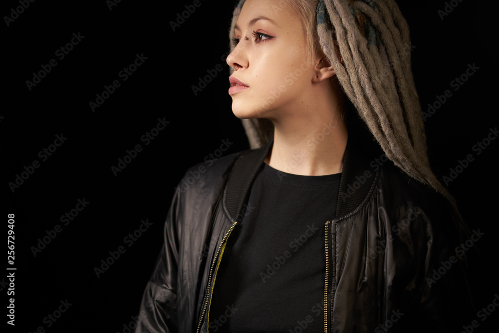 beautiful girl in a black jacket stylish on a black background on black background