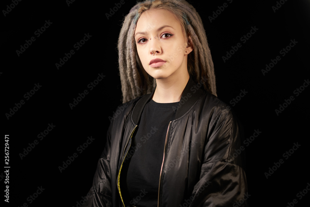 beautiful girl in a black jacket stylish on a black background on black background