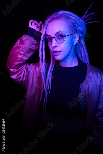beautiful girl in the light of neon colored lamps light blue purple on black background