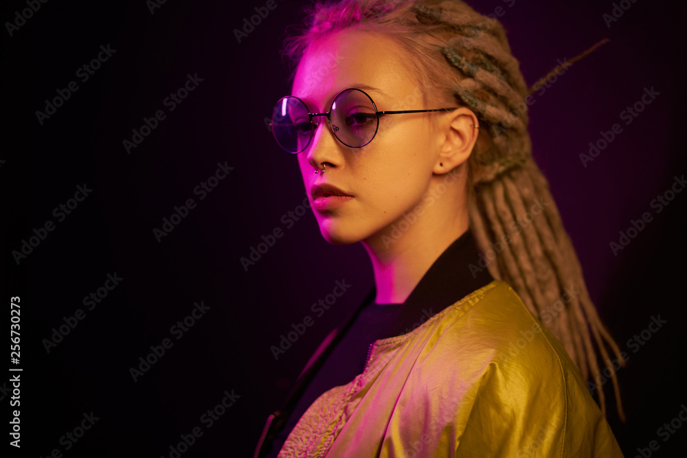 beautiful girl in the light of neon colored lamps light on black background yellow purple wearing glasses beautiful girl in the light of neon colored lamps light on black background yellow purple wearing glasses