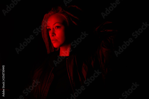 beautiful girl in the light of neon colored lamps light red on black background