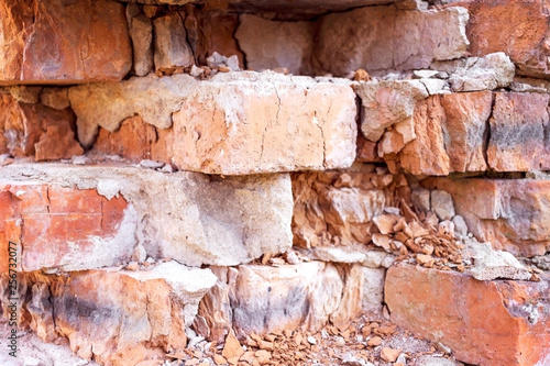 Red brick destroyed wall background. Old destroyed bricks, background and texture.