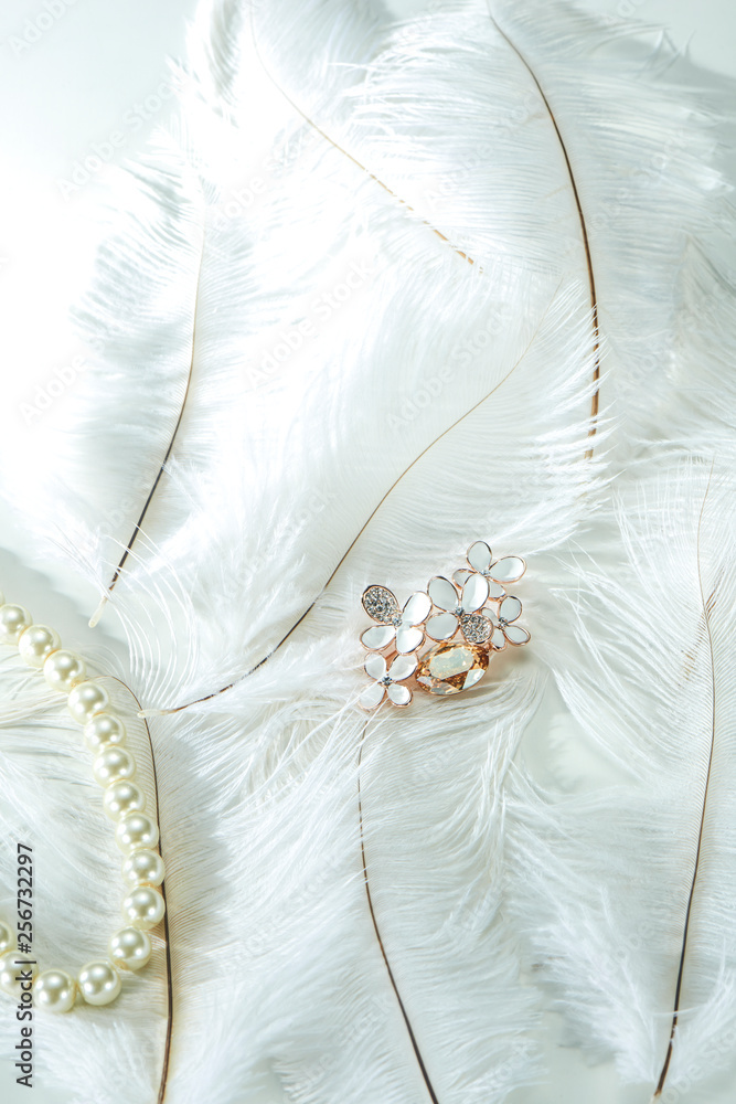 Obraz premium Pearl necklace on white feather