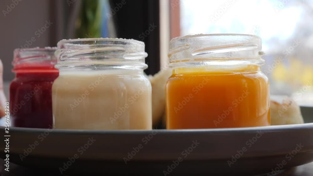 Tasty sweet small cheese pancakes on a plate with colorful jam jars breakfast in a cafe bar Tasty sweet small cheese pancakes on a plate with colorful jam jars breakfast in a cafe bar