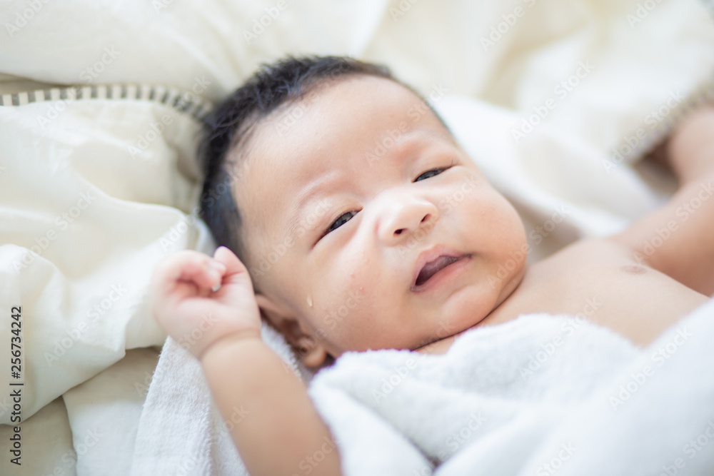 Funny infant baby boy lying on bed after wake up Funny infant baby boy lying on bed after wake up