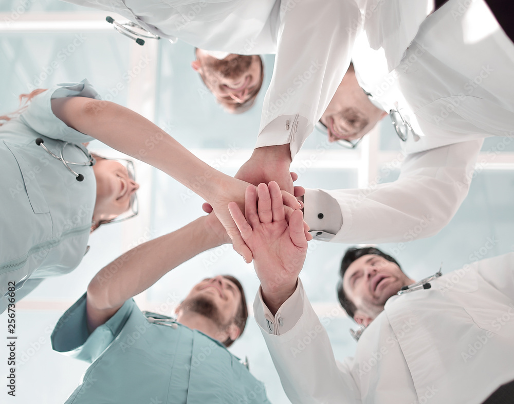 Obraz premium Health care workers demonstrating unity, bottom view