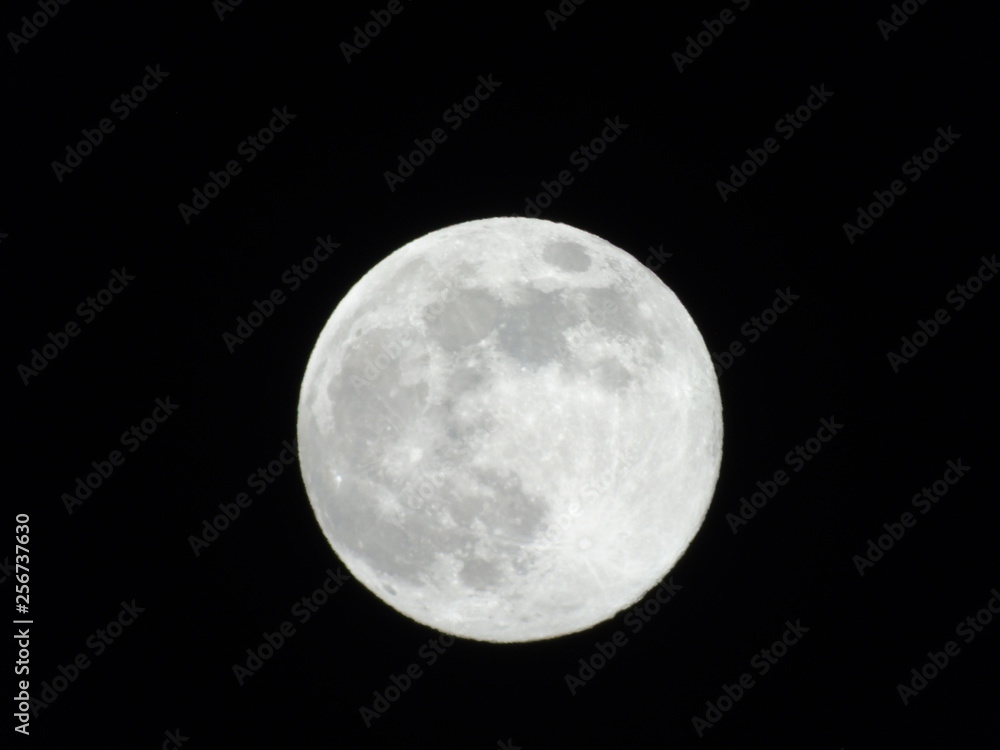 Obraz premium Genova, Italy - 03/20/2019: An amazing photography of the full moon over the city of Genova by night with a great clear sky in background and some stars