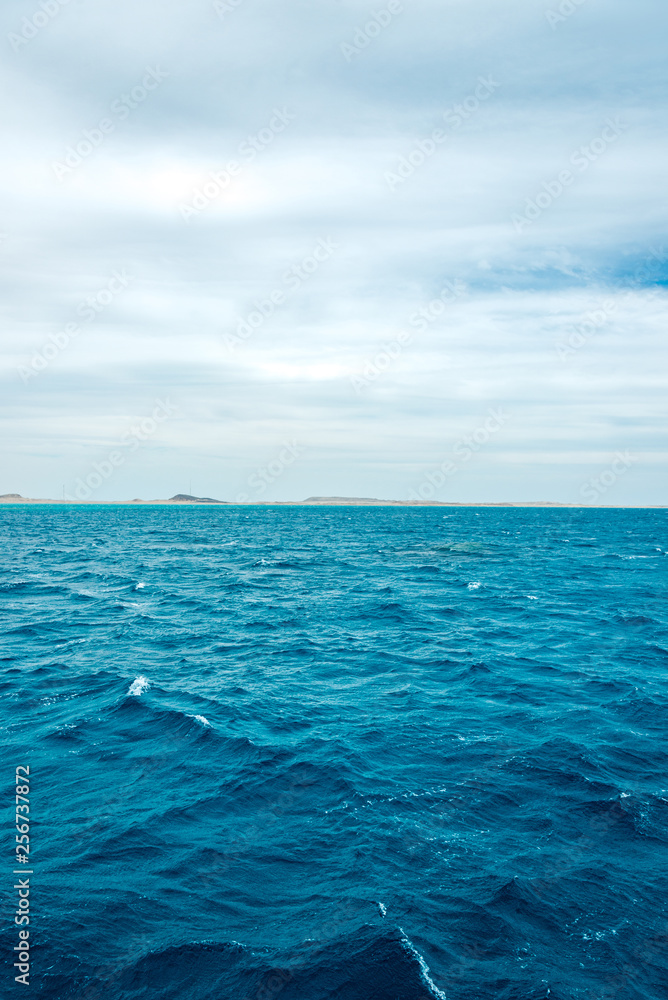 Obraz premium minimalistic seascape, blue sea and sky with white clouds on the whole frame