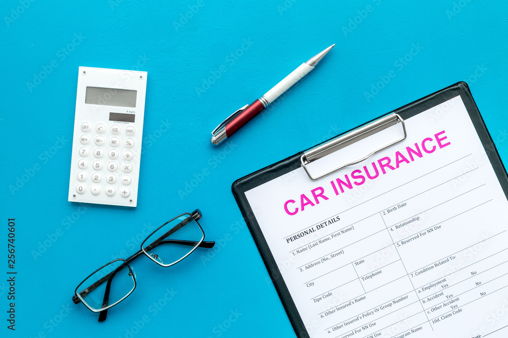 Car insurance form near glasses, calculator, pen on blue background top view Car insurance form near glasses, calculator, pen on blue background top view