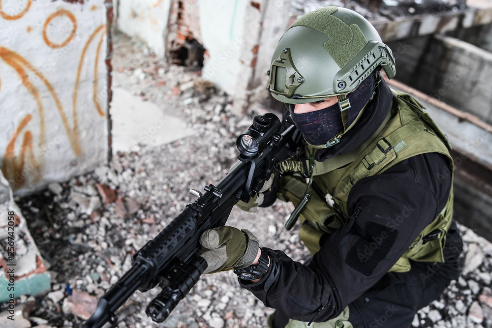 Young Special forces SWAT soldier aiming with assault rifle gun at the ruined building war terrorist battle zone Young Special forces SWAT soldier aiming with assault rifle gun at the ruined building war terrorist battle zone