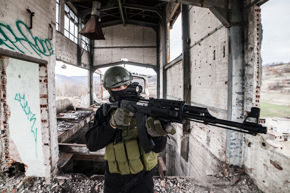 Fototapeta premium Specjalna policja wojskowa żołnierza w strefie bitwy terrorysta na schodach budynku celująca karabin szturmowy wiertarka airsoft