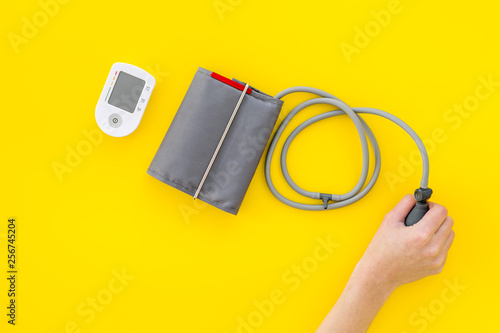 diagnostics of cardiac disease with pulsimeter on yellow background top view photo