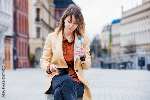 Young businesswoman eating salad and drinking water
