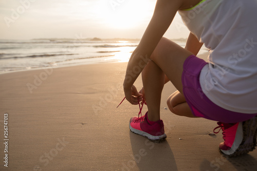 Woman runner ready to run on sunset beach