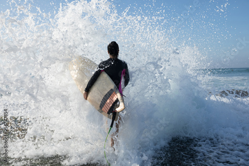 Photography Woman surfer with surfboard going to surf