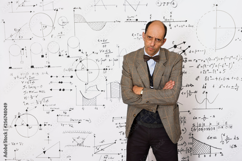Middle aged caucasian mathematician explaining equations on a white wall Middle aged caucasian mathematician explaining equations on a white wall