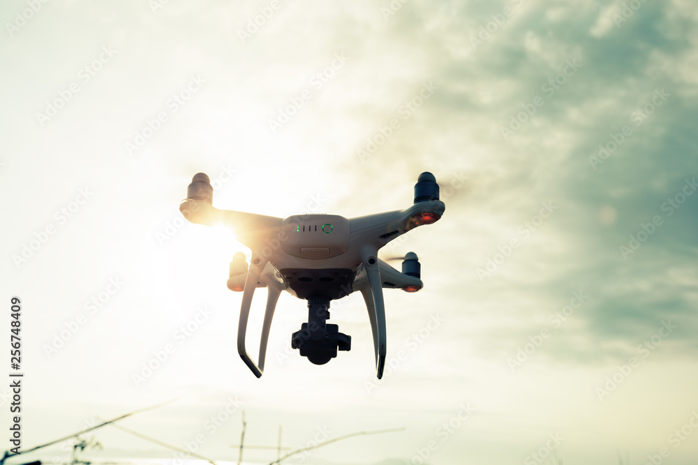 Drone flying in the air under cloudy sky Drone flying in the air under cloudy sky
