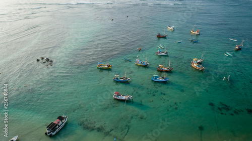 Aerial view of beautiful crystal clear ocean seascape with fishing boats in the coast