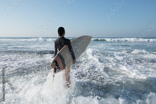 Woman surfer with surfboard going to surf © lzf
