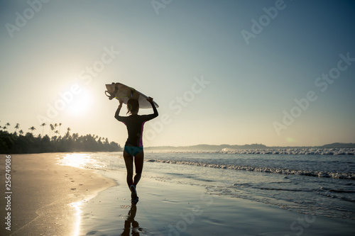 Woman surfer with surfboard going to surf