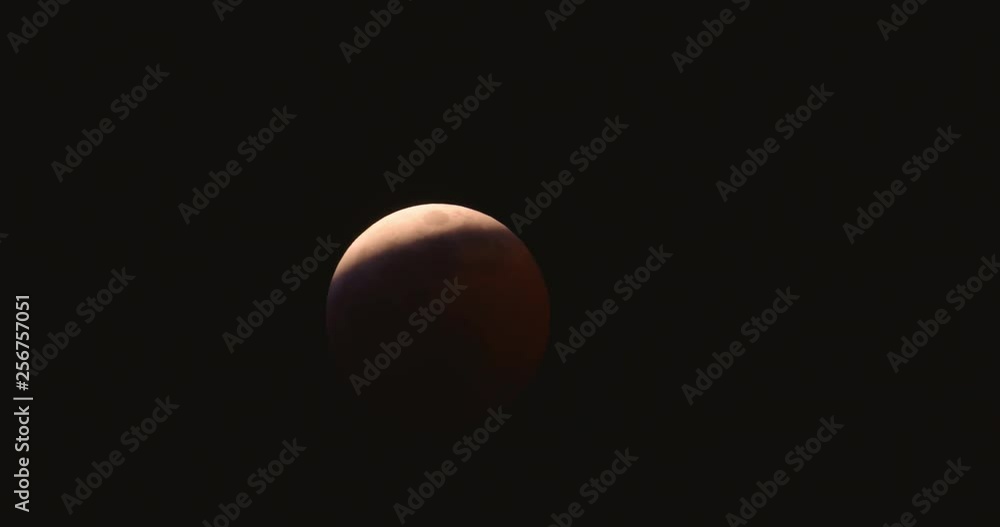 Lunar eclipse of the Moon about 80% complete across the face of a blood red moon in the night sky. Lunar eclipse of the Moon about 80% complete across the face of a blood red moon in the night sky.