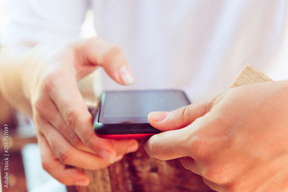 image of man's hand holding and touching a smartphone