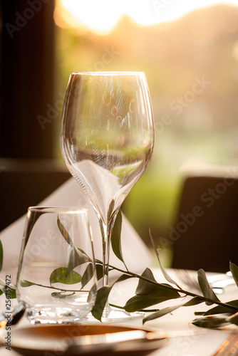 Champagne glass and beautiful flowers on the dining room table in a luxurious room with warm lighting
