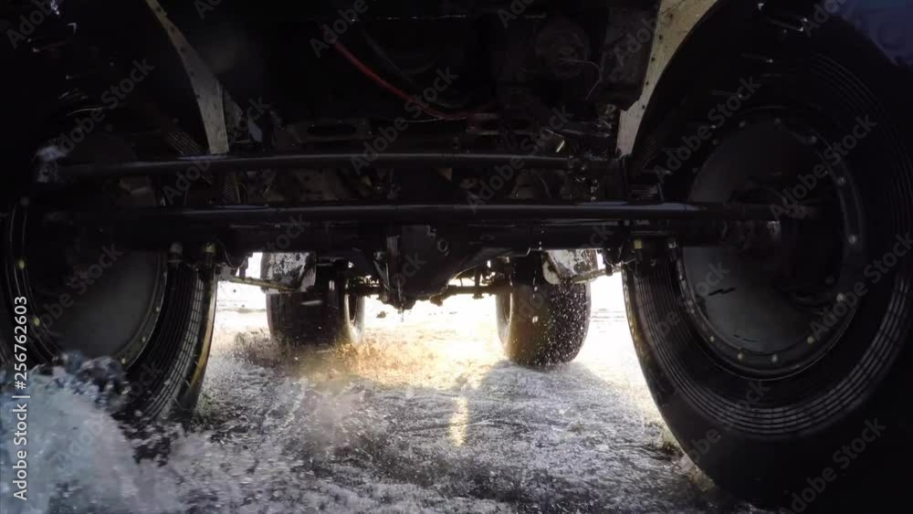Dynamic gopro view from car bottom side. Swamp buggy is driving fast on melting snow and puddles Dynamic gopro view from car bottom side. Swamp buggy is driving fast on melting snow and puddles