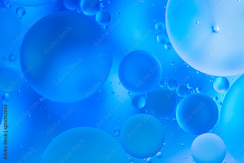 transparent glasses with water with oily drops on colorful background 